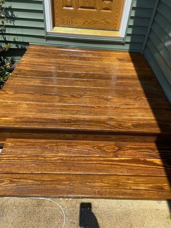 Shiny, freshly stained wooden porch steps leading to a front door.