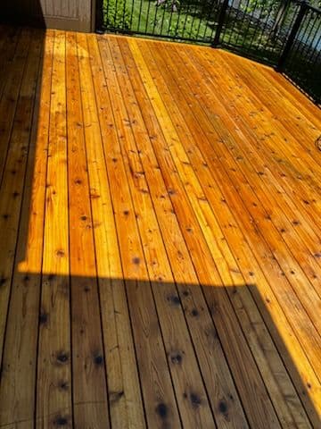 Well-maintained wooden deck with a rich, glossy finish and natural wood grain detail.